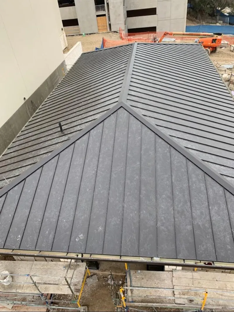 Commercial metal roof construction with crane equipment in Kensington